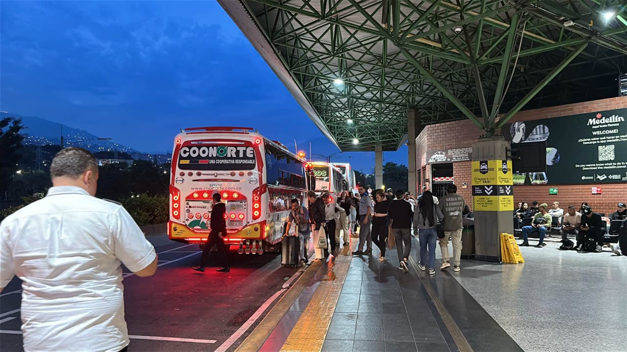 Bus Coonorte y viajeros con maletas en un andén de la imagen oficial de Terminales Medellín. Foto de contexto · fecha de toma no verificada.