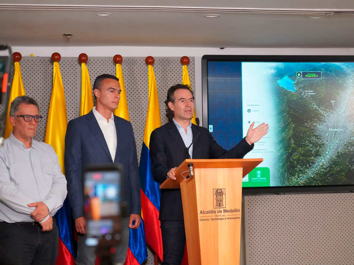 Federico Gutiérrez anuncia la pausa del racionamiento en una rueda de prensa en Medellín el 14 de septiembre, ante un mapa de los embalses y acompañado de funcionarios.